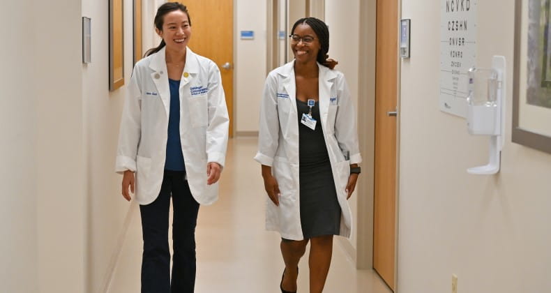 two medical students walking through a hospital hallway