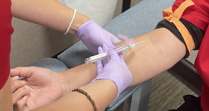 An image of a phlebotomist drawing blood from a patient