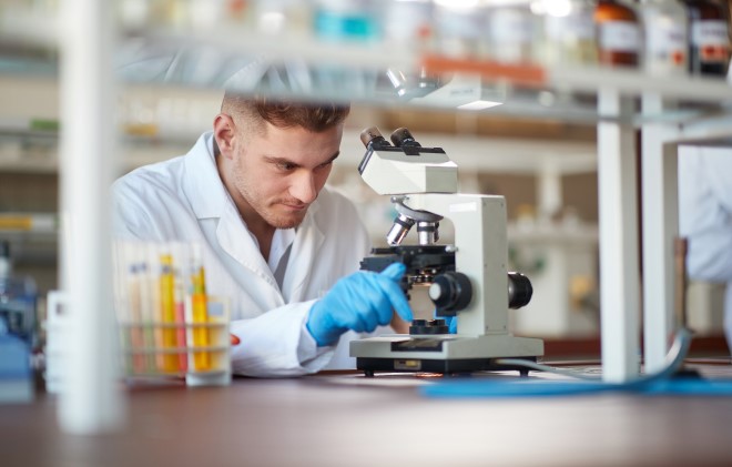 an image of a pharmacist looking through a microscope