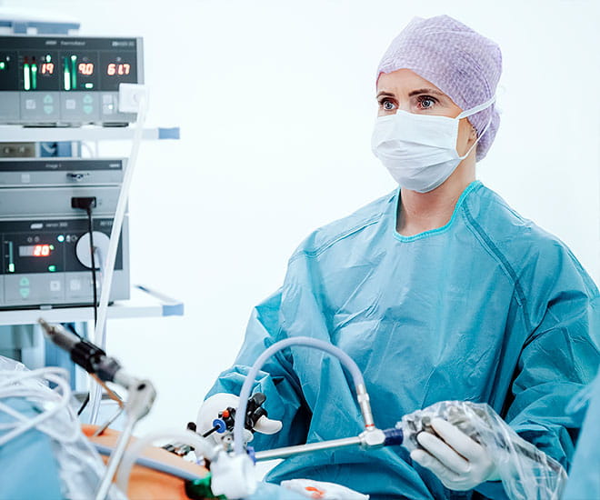 A female surgeon is pictured performing a minimally invasive surgical procedure.