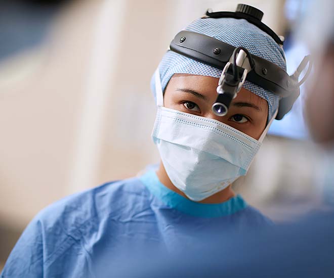 Surgeon in the operating room as she conducts a procedure on a patient.