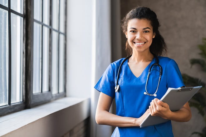 A smiling medical student near a window