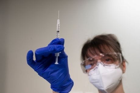 Nurse holds vaccine.