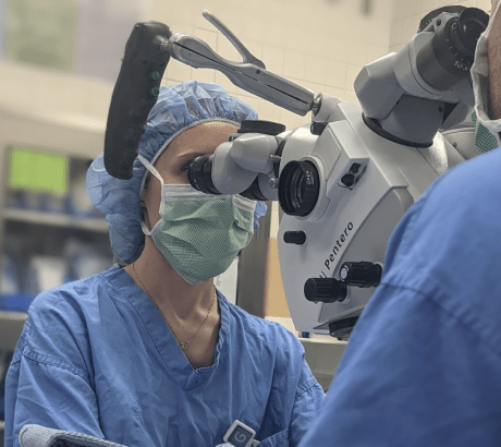 an image of a plastic surgery resident looking through a microscope