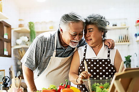 Happy couple preparing a stroke prevention diet.