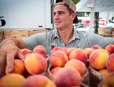 A man selling peaches